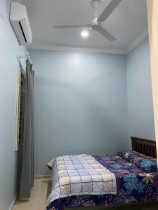 um quarto com uma cama e uma ventoinha de tecto em dRose Homestay em Kuala Terengganu