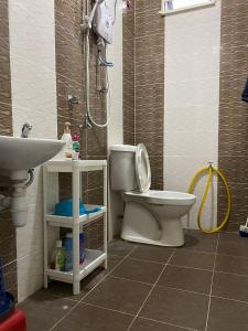 uma casa de banho com um chuveiro, um WC e um lavatório. em dRose Homestay em Kuala Terengganu