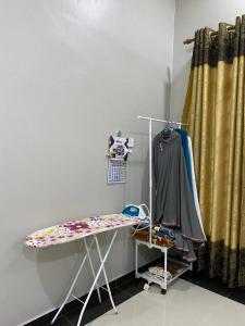 a room with a table and a curtain at dRose Homestay in Kuala Terengganu