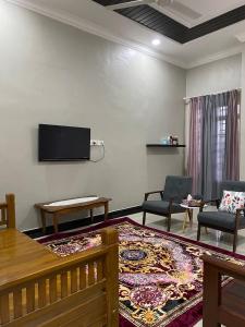 uma sala de estar com uma televisão de ecrã plano na parede em dRose Homestay em Kuala Terengganu