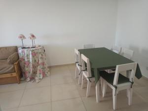comedor con mesa verde y sillas en El Serrano 2 en Tandil