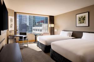 オークランドにあるスタンフォード プラザ オークランドのベッド2台と大きな窓が備わるホテルルームです。