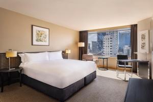una camera d'albergo con un grande letto e una grande finestra di JW Marriott Auckland ad Auckland