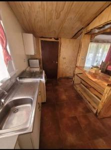 a small kitchen with a sink and a stove at Cabaña con estacionamiento in Panguipulli