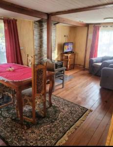 a living room with a table and a couch at Cabaña con estacionamiento in Panguipulli