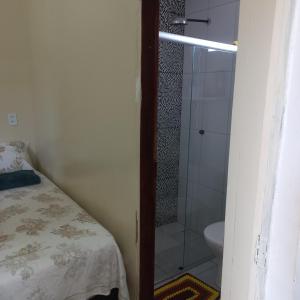 a bathroom with a shower and a bed and a toilet at kitnet completa no Centro in Carolina