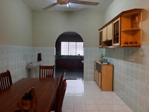 cocina y comedor con mesa y comedor en To' Teh Homestay, en Ipoh