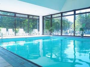 a large swimming pool with blue water in a building at Res Le Parc des Vosges du Nord, Bitche, holiday home for 5 pers in Bitche