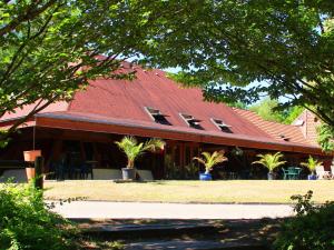 a large building with a red roof with palm trees at Res Le Parc des Vosges du Nord, Bitche, holiday home for 5 pers in Bitche