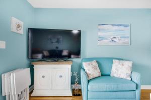 un soggiorno blu con divano blu e TV di Crabby Lagoon C104 a Panama City Beach