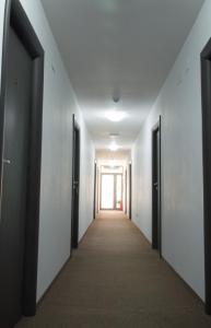 an empty corridor in an office building with a hallway at Motel Alexander in Olteniţa