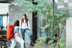 two women standing outside of a building talking to a woman at NAGI Hiroshima Hotel and Lounge in Hiroshima