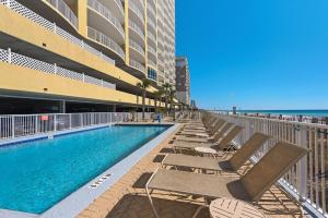 uma piscina com espreguiçadeiras ao lado de um edifício em Emerald Isle 1201 em Panama City Beach