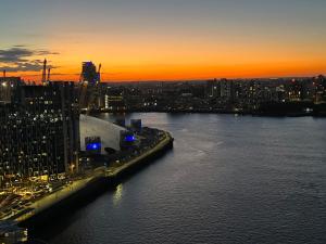 a view of a city at sunset with a river at ExcelLodge in London