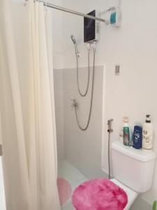 y baño con ducha y alfombra rosa. en Phirst Park Homes Townhouse en Lipa