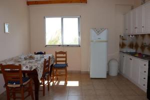 a kitchen with a table with chairs and a refrigerator at Anastassia EG in Koroni