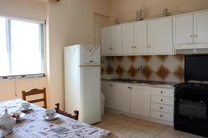 a kitchen with a table and a white refrigerator at Anastassia EG in Koroni