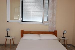 1 dormitorio con 1 cama con 2 mesas y una ventana en Anastassia OG, en Koroni 29 fotos más