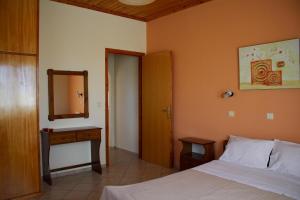 a bedroom with a bed and a dresser and a mirror at Orfanos 4 in Armenoí