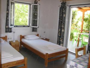 2 bedden in een kamer met een raam en een patio bij Nikos 8 in Kakóvatos