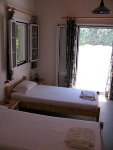 een slaapkamer met 2 bedden en een raam bij Nikos 8 in Kakóvatos