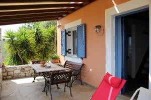 a patio with a table and chairs on a house at Alexia in Selinitsa