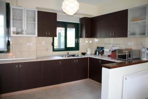 una cocina con armarios de color marrón oscuro y una ventana en Iliana, en Skotina