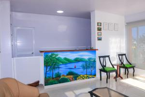 una stanza con due sedie e un dipinto sul muro di Hotel Posada Enilda a Providencia
