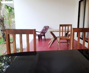 Duas cadeiras e uma mesa num alpendre em Louis Garden Homestay em Mararikulam