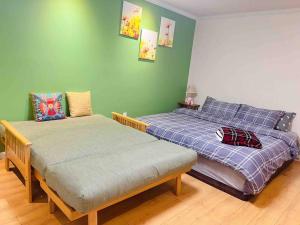 two beds in a room with green walls at Separate access suite , separate kitchen, bathroom in Surrey
