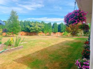 a yard with pink flowers and a fence at Separate access suite , separate kitchen, bathroom in Surrey