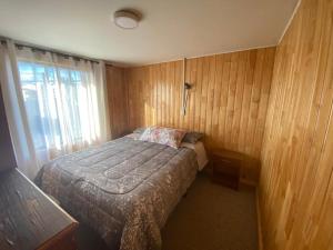 um pequeno quarto com uma cama e uma janela em Hospedaje & Alojamientos Hilda em Puerto Montt