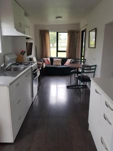 a kitchen and living room with a couch and a table at Te Puru Holiday Park in Thames