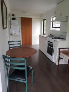 a kitchen with a table and chairs in a kitchen at Te Puru Holiday Park in Thames