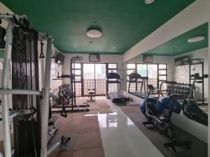 einen Fitnessraum mit mehreren Laufbändern und Maschinen in einem Zimmer in der Unterkunft Cozy studio 5 min walk from Ayala, Cebu Business Park in Cebu City