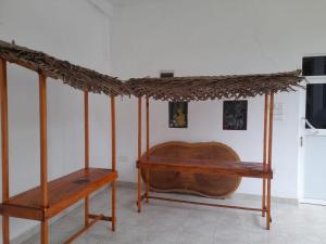 Pokój z drewnianym łóżkiem i stołem w obiekcie Green Parrot Family Resort w mieście Polonnaruwa