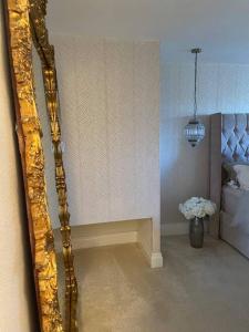 a mirror in a room with a bed and a vase of flowers at Modern home in quiet neighbourly street, perfect for Work From Home, quick links to centre in Manchester