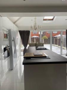a kitchen with a black counter top and a refrigerator at Modern home in quiet neighbourly street, perfect for Work From Home, quick links to centre in Manchester