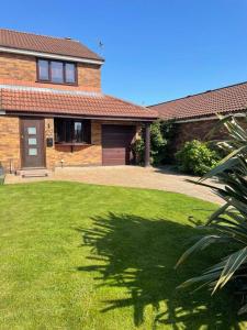 a brick house with a lawn in front of it at Modern home in quiet neighbourly street, perfect for Work From Home, quick links to centre in Manchester