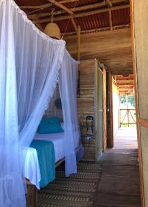 1 dormitorio con 1 cama con mosquitera en Palmarío Hostal en Guachaca