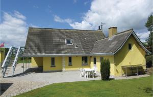 a yellow house with a table and chairs at Amazing Home In Rudkbing With 4 Bedrooms And Wifi in Spodsbjerg