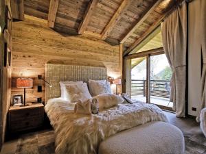 a bedroom with a large bed with a large window at Chalet Méribel, 8 pièces, 13 personnes - FR-1-613-52 in Méribel