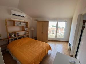 sypialnia z łóżkiem i dużym oknem w obiekcie Appartement climatisé 2 pièces avec solarium pour 4 personnes, parking privé, proche plage - FR-1-335-166 w Hyères