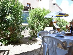 une table bleue avec des chaises et un parasol dans l'établissement Maison Gruissan, 2 pièces, 6 personnes - FR-1-229-823, à Gruissan