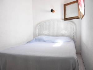 Cette petite chambre dispose d'un lit blanc et d'une fenêtre. dans l'établissement Maison Gruissan, 2 pièces, 6 personnes - FR-1-229-823, à Gruissan