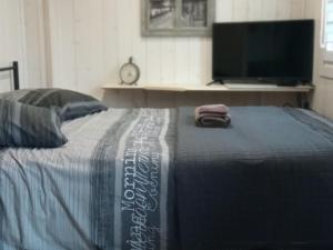 a bedroom with a bed with a desk and a television at Chambre élégante, calme et adaptée PMR avec Wi-Fi, climatisation, parking et table d'hôtes - FR-1-590-266 in Noyers