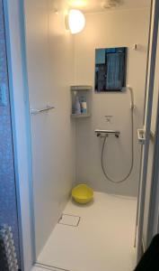 uma casa de banho com um chuveiro e um banco amarelo em B&B HOTTA em Sapporo