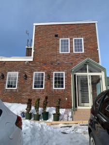 a brick house with potted plants in front of it at B&B HOTTA in Sapporo