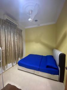 letto blu in una camera con soffitto di Qaseh Aida Guesthouse a Kampong Tanah Merah