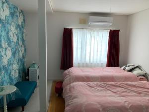 a small bedroom with a bed and a window at B&B HOTTA in Sapporo